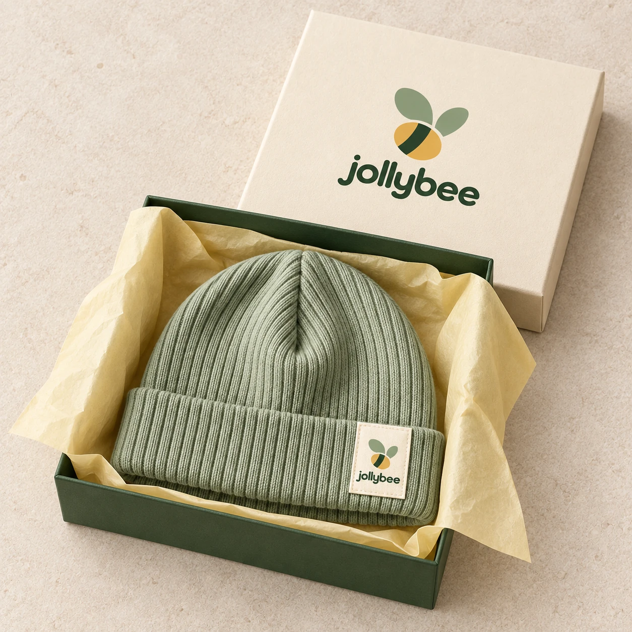 Jollybee sage ribbed beanie placed inside its visible open branded box